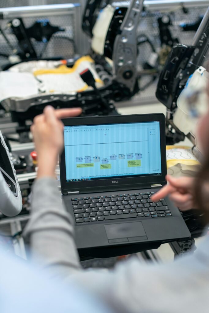 pexels-photo-3862605-3862605 Engineers using a laptop to analyze software data in an industrial workshop setting.